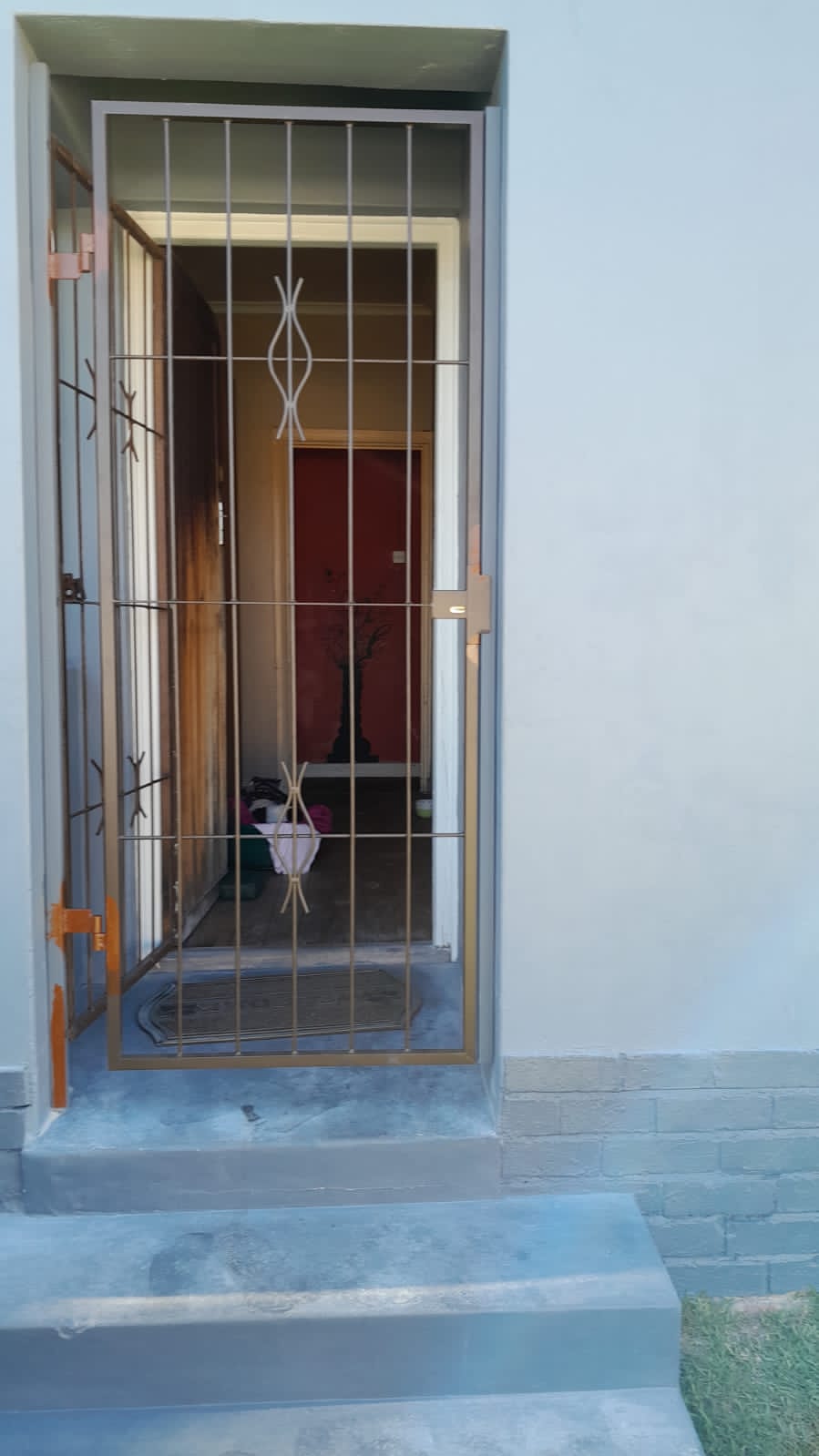 Door security gate with decorative scrolls